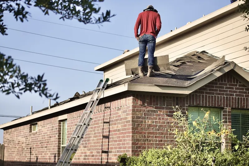 Professional roofer working on a residential roof in Felton